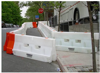 A barricade used to channel pedestrians into the roadway parallel to a closed sidewalk eliminates the need for pedestrians to cross the street to get to an open sidewalk.