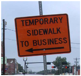 Post-mounted sign with arrow directs pedestrians to a temporary sidewalk that allows them to access businesses.